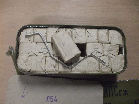 Freshly opened 'Spam Can' of Russian military surplus 7.62x54mmR ammunition.  22 paper packets of 20 rounds each.  One central packet lifted out with the cloth ribbon.