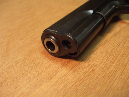 Press the recoil spring plug and start to rotate the barrel bushing.