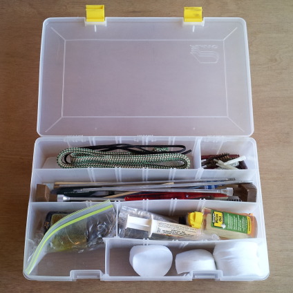 Plastic case filled with gun cleaning tools and supplies.