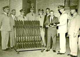 Garand showing his rifle design to several military officers in the early 1950s.