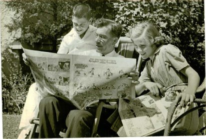 John Garand and his children read the comics.