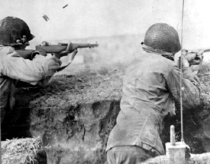 The M1 in action, the last round's cartridge and the empty clip are being ejected.