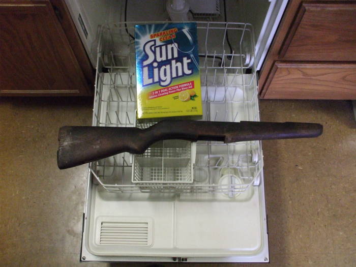 An M1 Garand rifle stock about to get cleaned in a dishwasher.