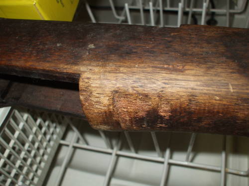 Dishwasher cleaning of an M1 Garand rifle stock.  Dark and dirty wood before cleaning.