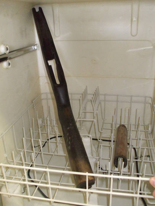 An M1 Garand rifle stock in the dishwasher, preparing to be cleaned.