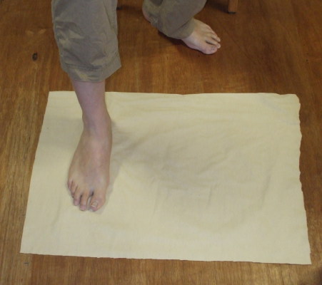 Start to wrap your portyanki by standing on the cloth.
